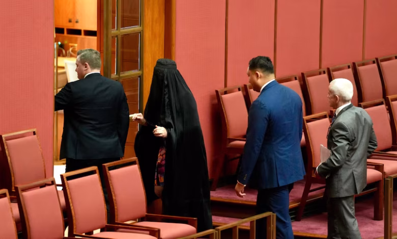 Pauline Hanson leaves the Senate, wearing a burka, after proceedings were suspended. (ABC News: Callum Flinn)