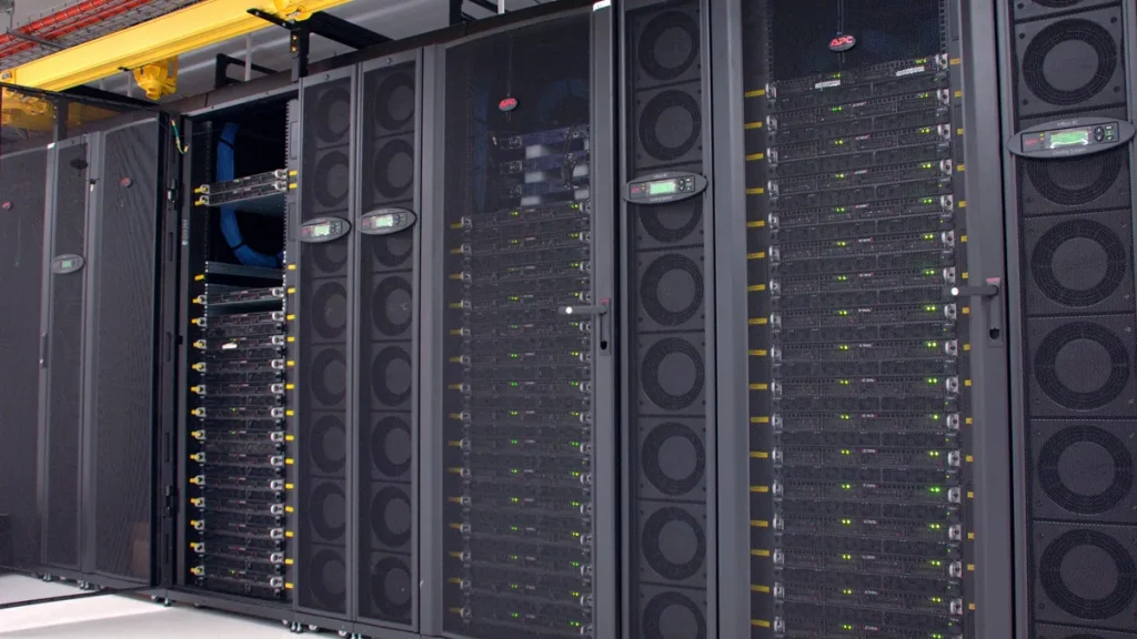 Rows of black server cabinets holding a GPU cluster in a CSIRO data centre, with green status lights lit along the racks.