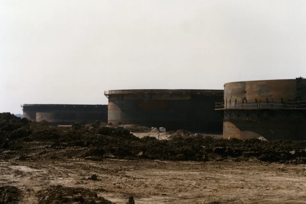 Large cylindrical crude oil storage tanks under construction at the St James terminal of the US Strategic Petroleum Reserve, behind mounds of excavated earth. Archive photograph; not from the G7 announcement.