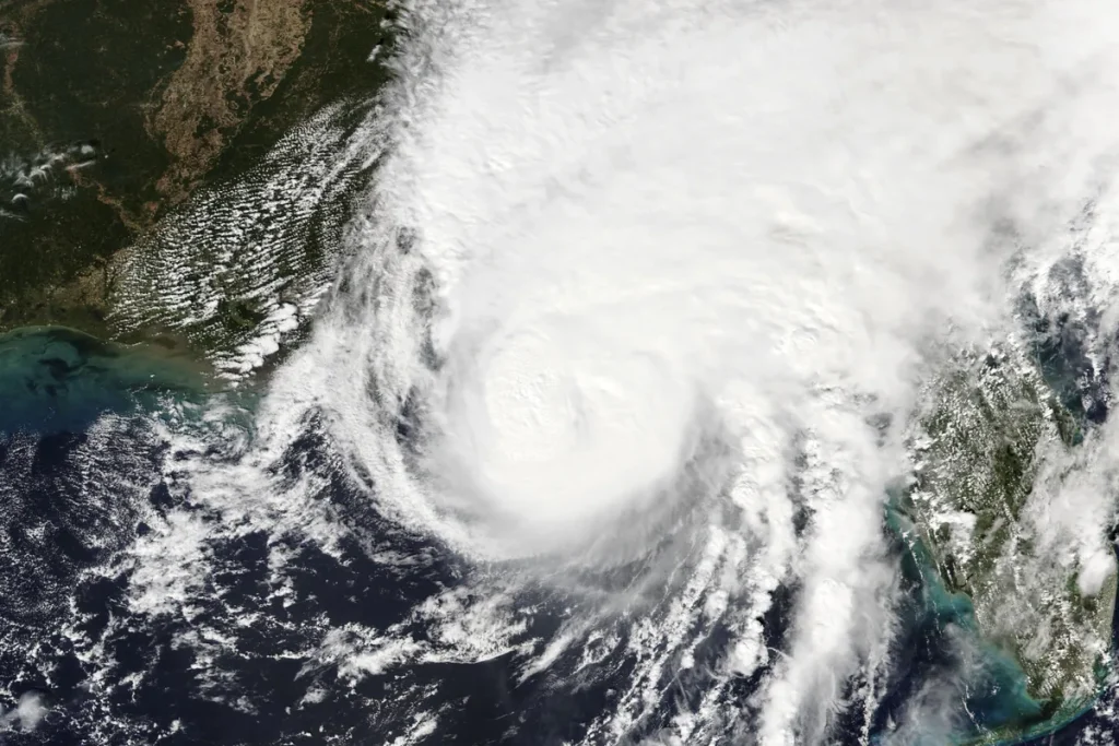Satellite view of Hurricane Isaias, a large white spiral of cloud over the dark Gulf of Mexico, with the US Gulf Coast at top left and the Florida peninsula at right.